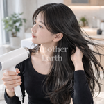 ドライヤーで髪を乾かす女性